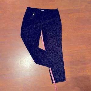 Black pull on ankle pants. Monochromatic rosette pattern print.